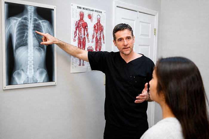 Dr. Richard Collin reviewing spinal X-rays with a patient in Buford Georgia